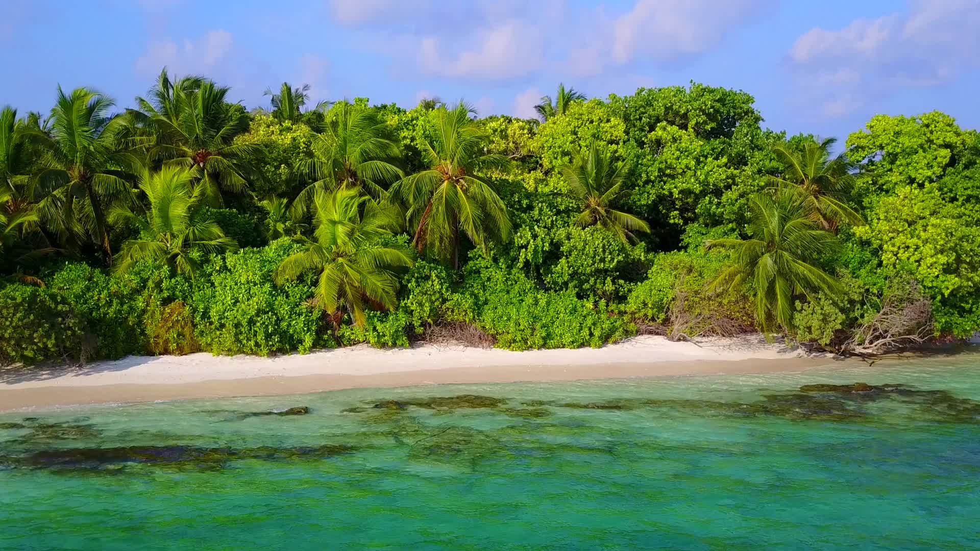 在阳光下清澈的环礁湖下白色的海滩背景打破了完美的岛屿海滩视频的预览图