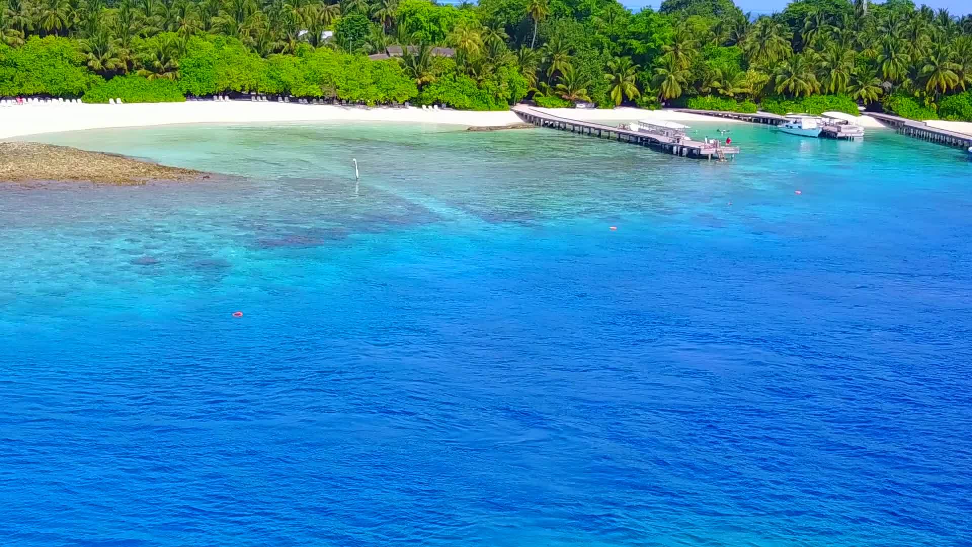 蓝水和白沙背景的珊瑚礁附近的风景视频的预览图