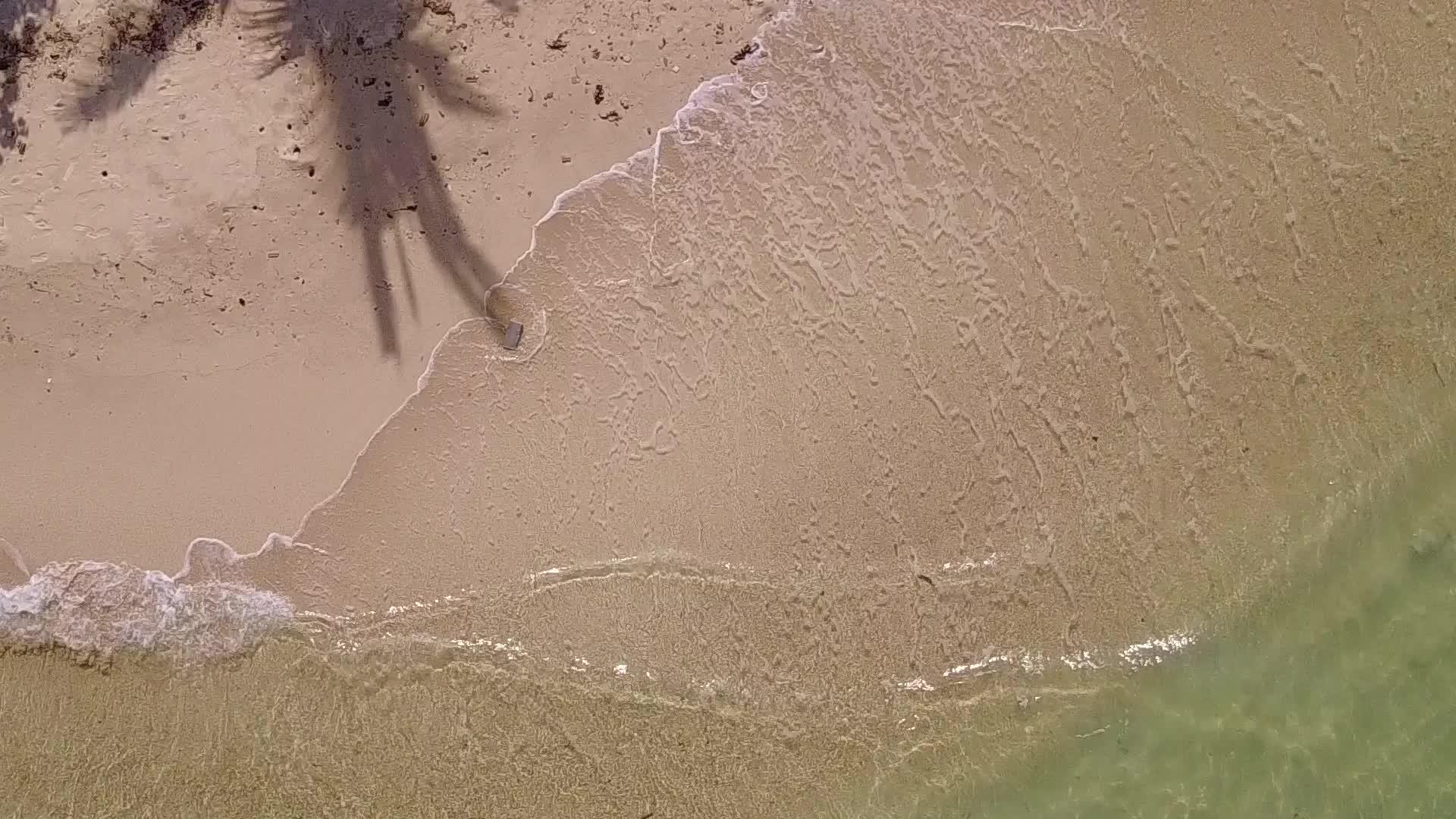 蓝色海洋和接近冲浪的白色海滩背景视频的预览图