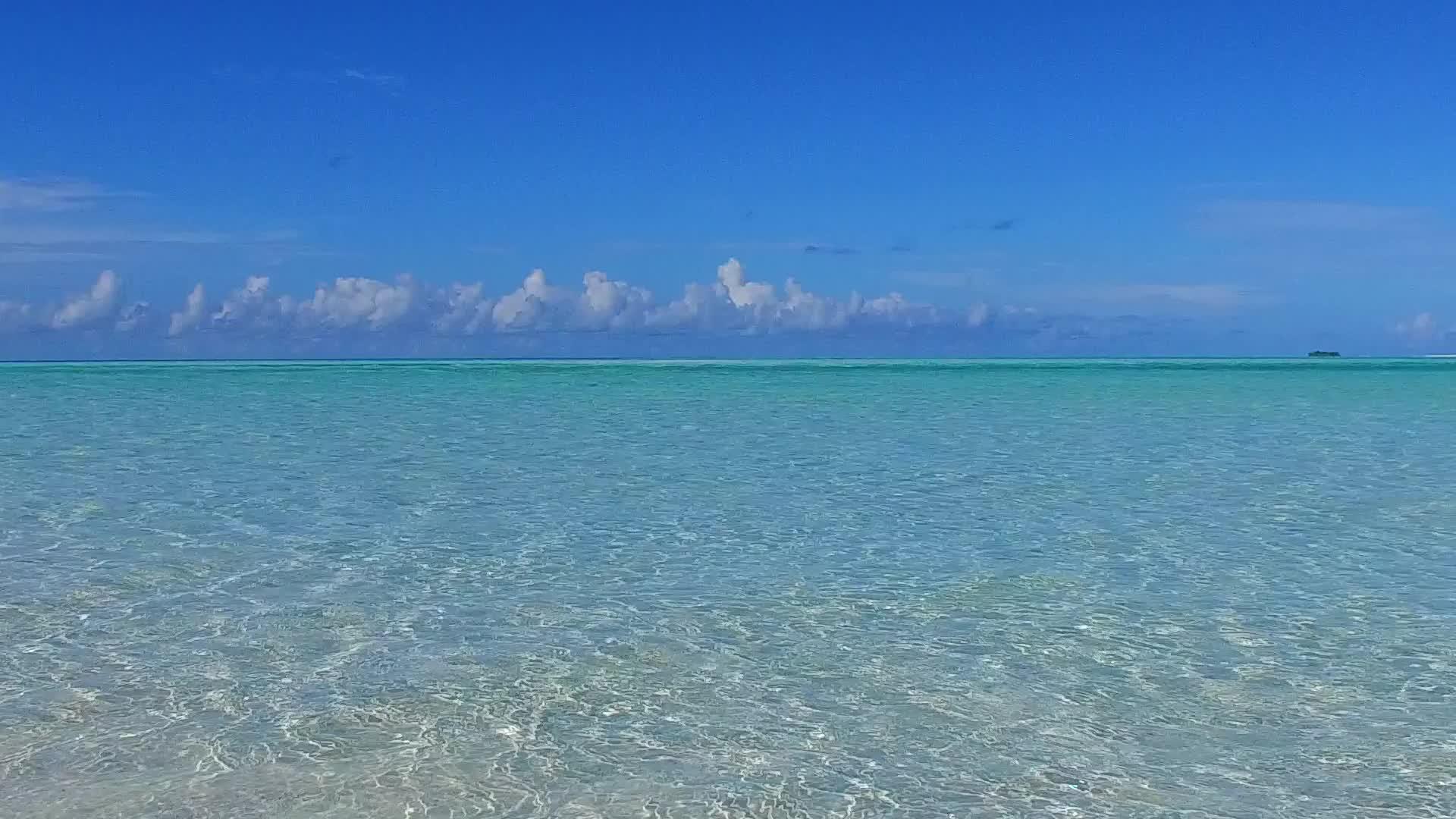 海浪附近的绿松石环礁湖有一个白色的沙子背景有一个奇怪的岛屿海滩视频的预览图