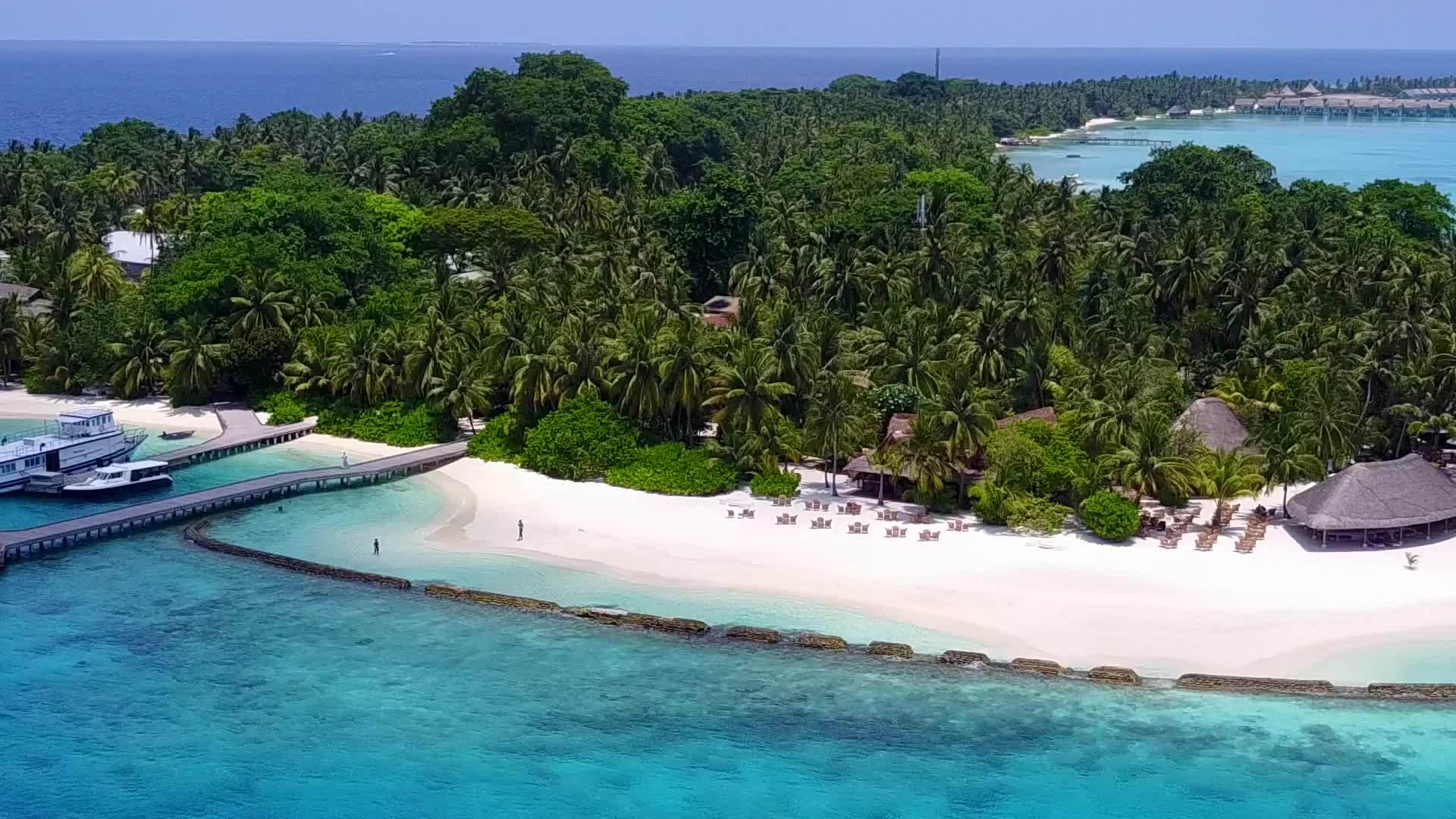 以蓝色环礁湖和白色沙滩为背景在度假胜地附近航行视频的预览图