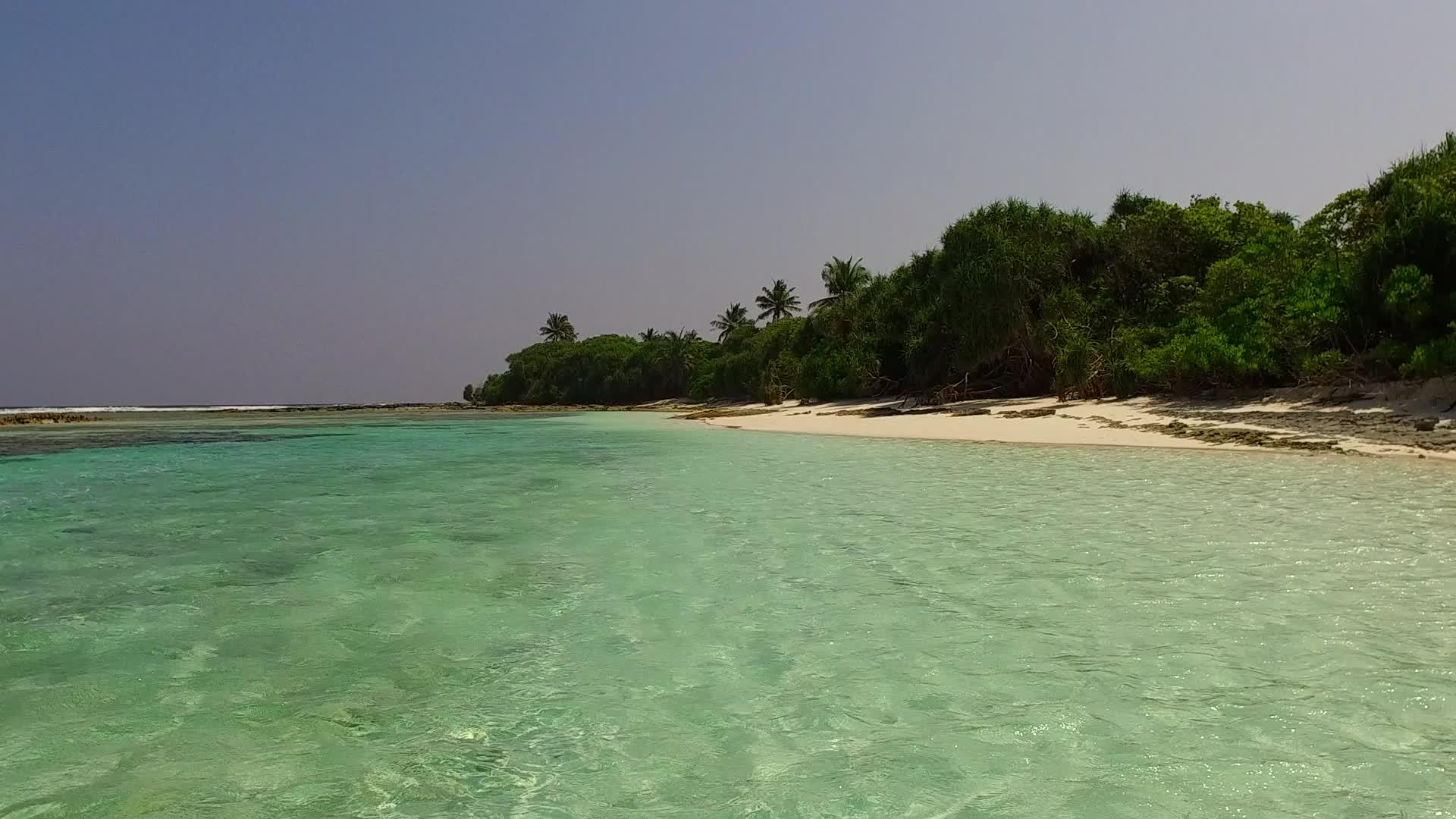 以白沙为背景的透明海洋在度假村附近复制宁静度假村海滩海滩视频的预览图