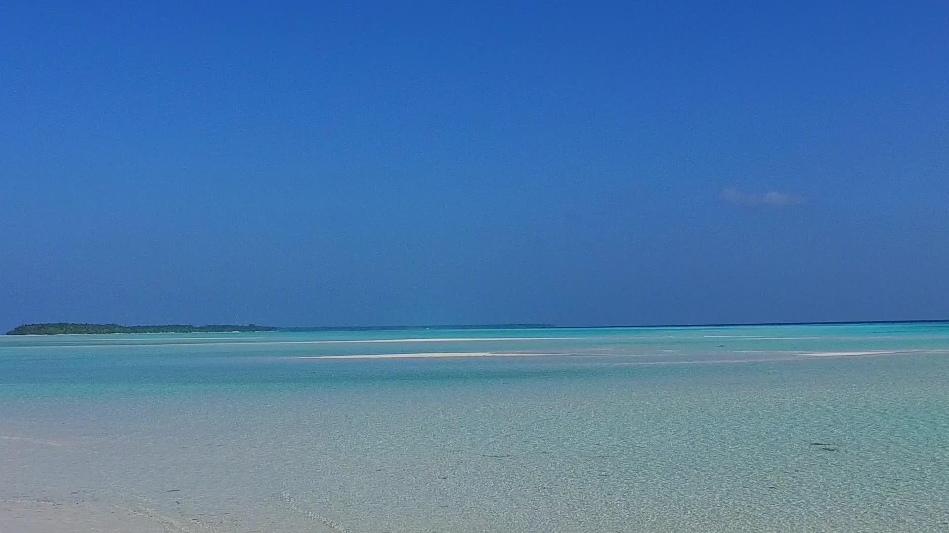 沿着蓝绿色海洋和度假胜地附近的白色海滩背景视频的预览图