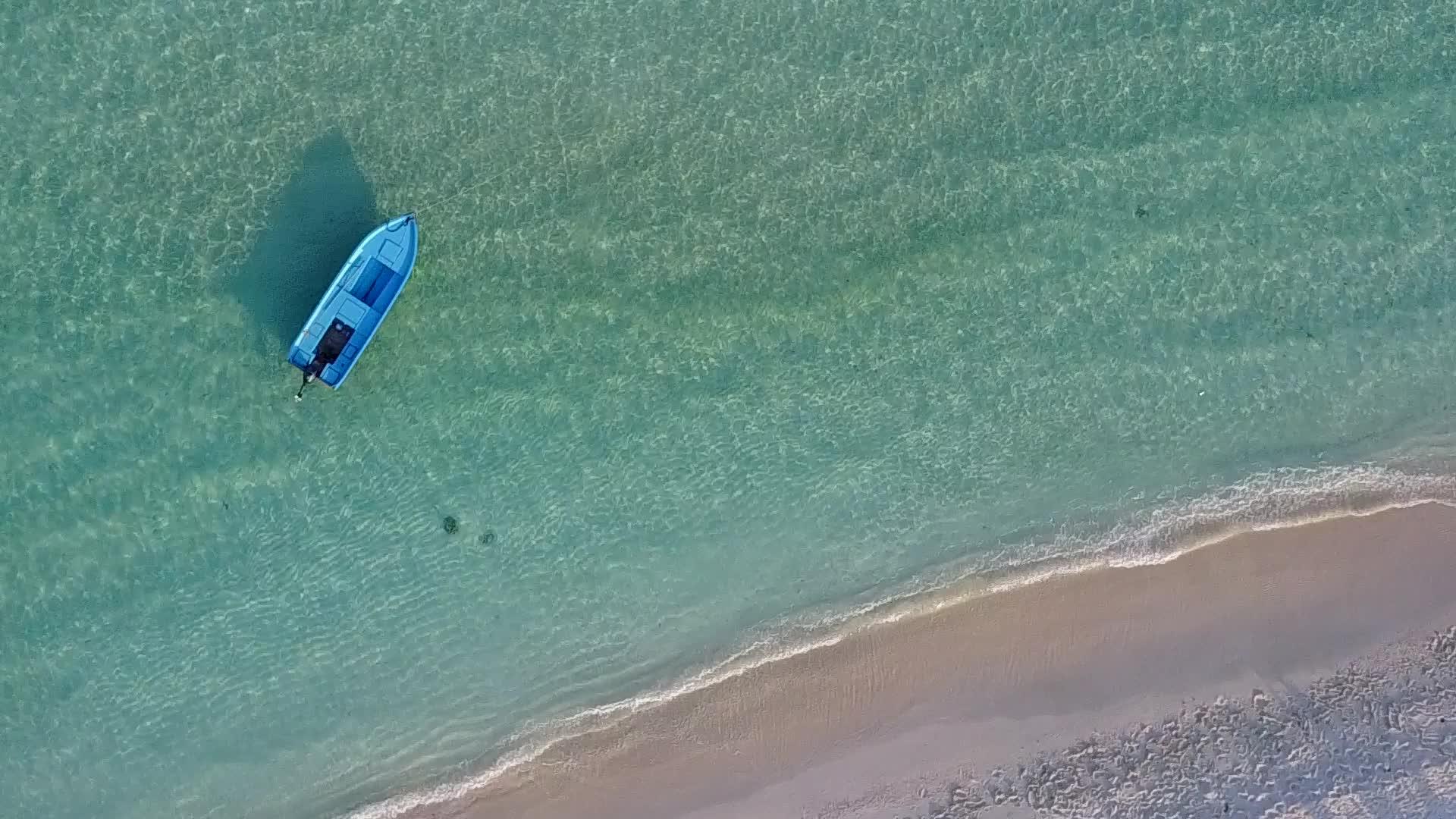 平静的旅游海滩打破了海浪附近的蓝色海洋视频的预览图