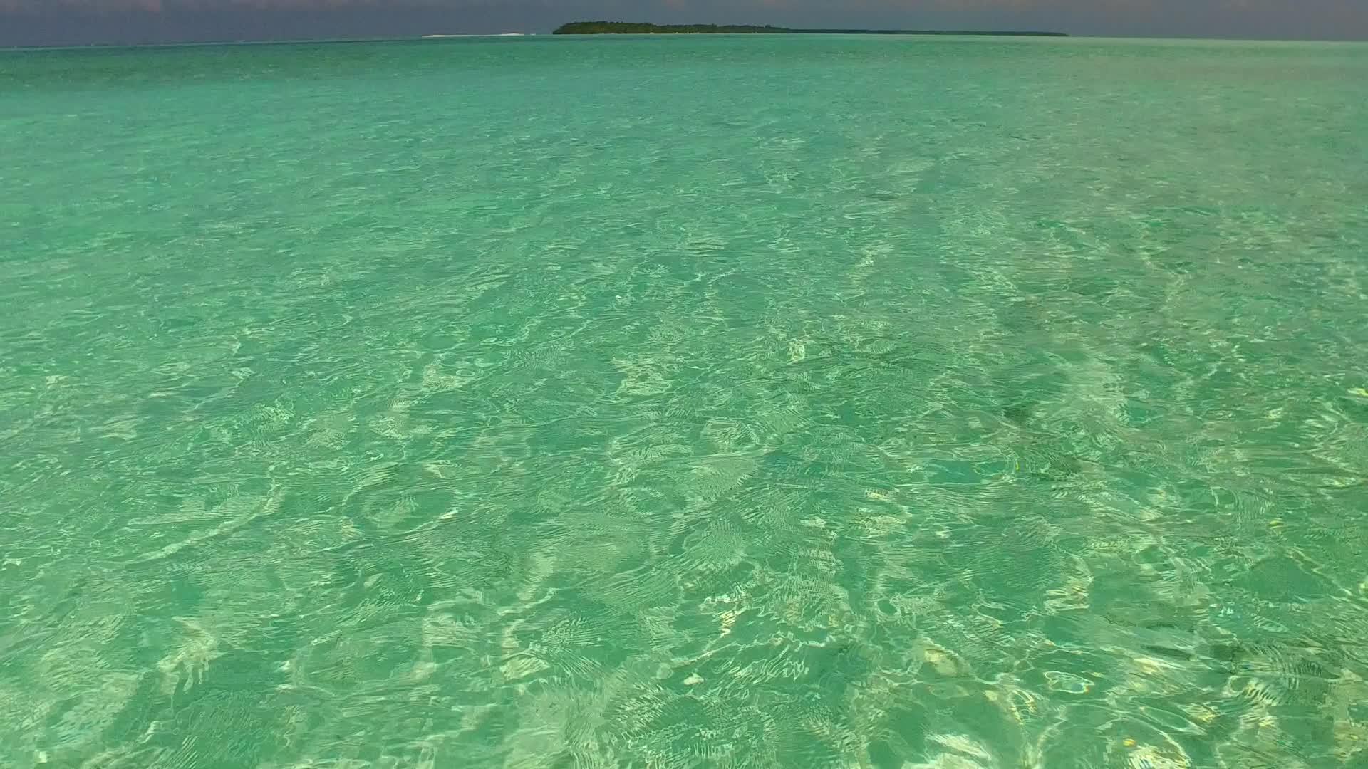 蓝色海滩在蓝色海滩上航行棕榈树附近有白色沙滩背景视频的预览图