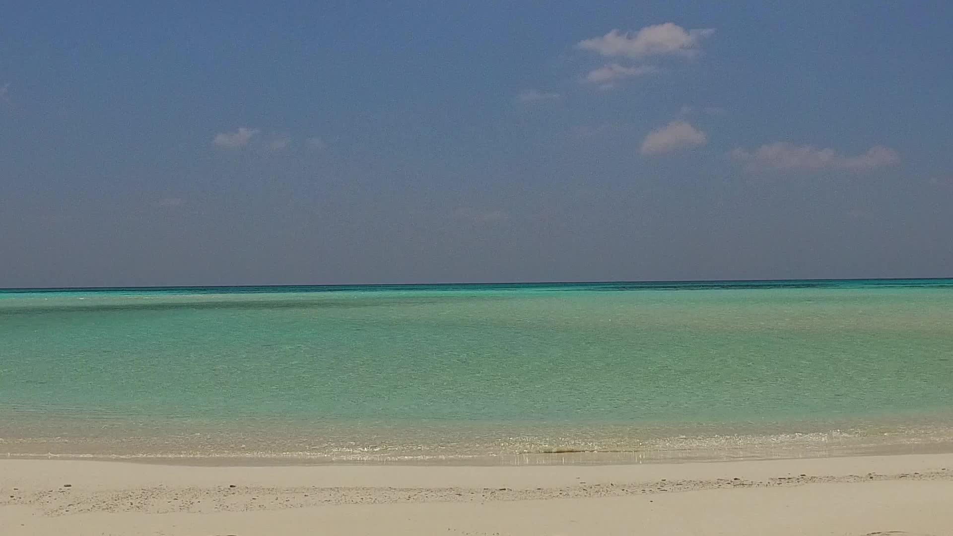 当接近冲浪时蓝色环礁湖有一个白色的沙底背景视频的预览图