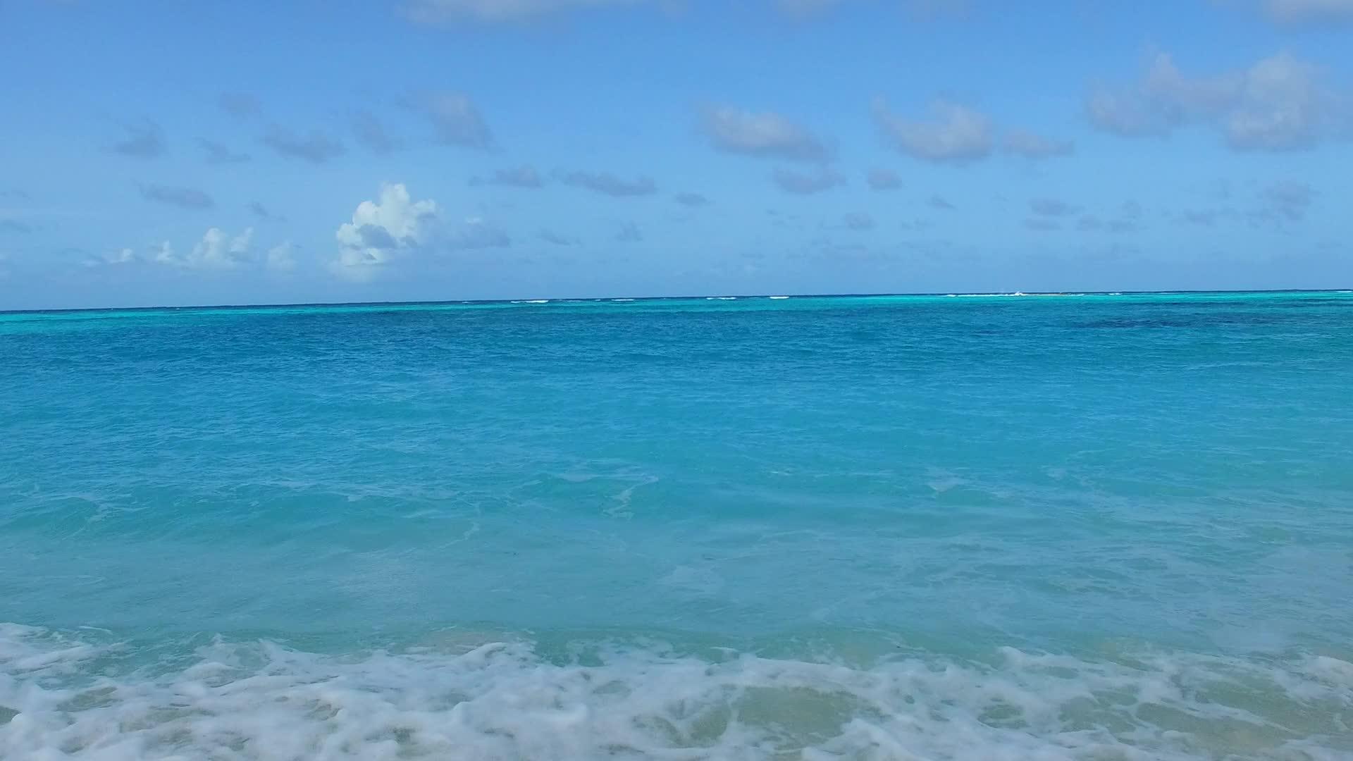 蓝色泻湖美丽海滩航行摘要靠近冲浪的白色沙滩背景视频的预览图