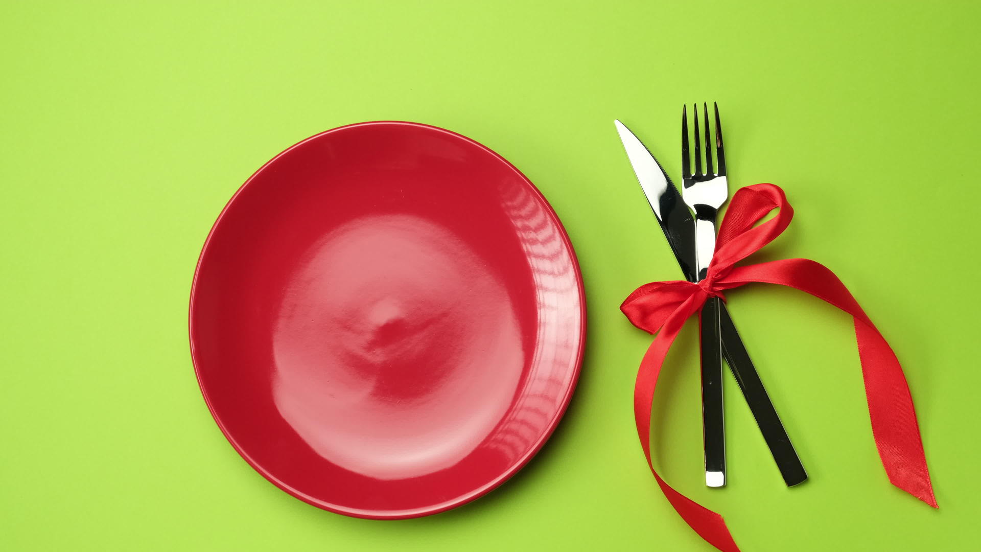 红色圆盘刀叉和圣诞装饰绿色背景视频的预览图