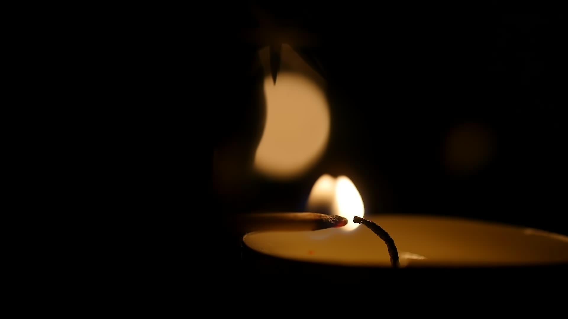 男人用火柴在庙里点燃蜡烛 在黑暗中守夜视频的预览图