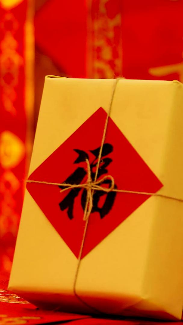 红色喜庆背景前悬挂红包福字礼盒实拍静物视频视频的预览图