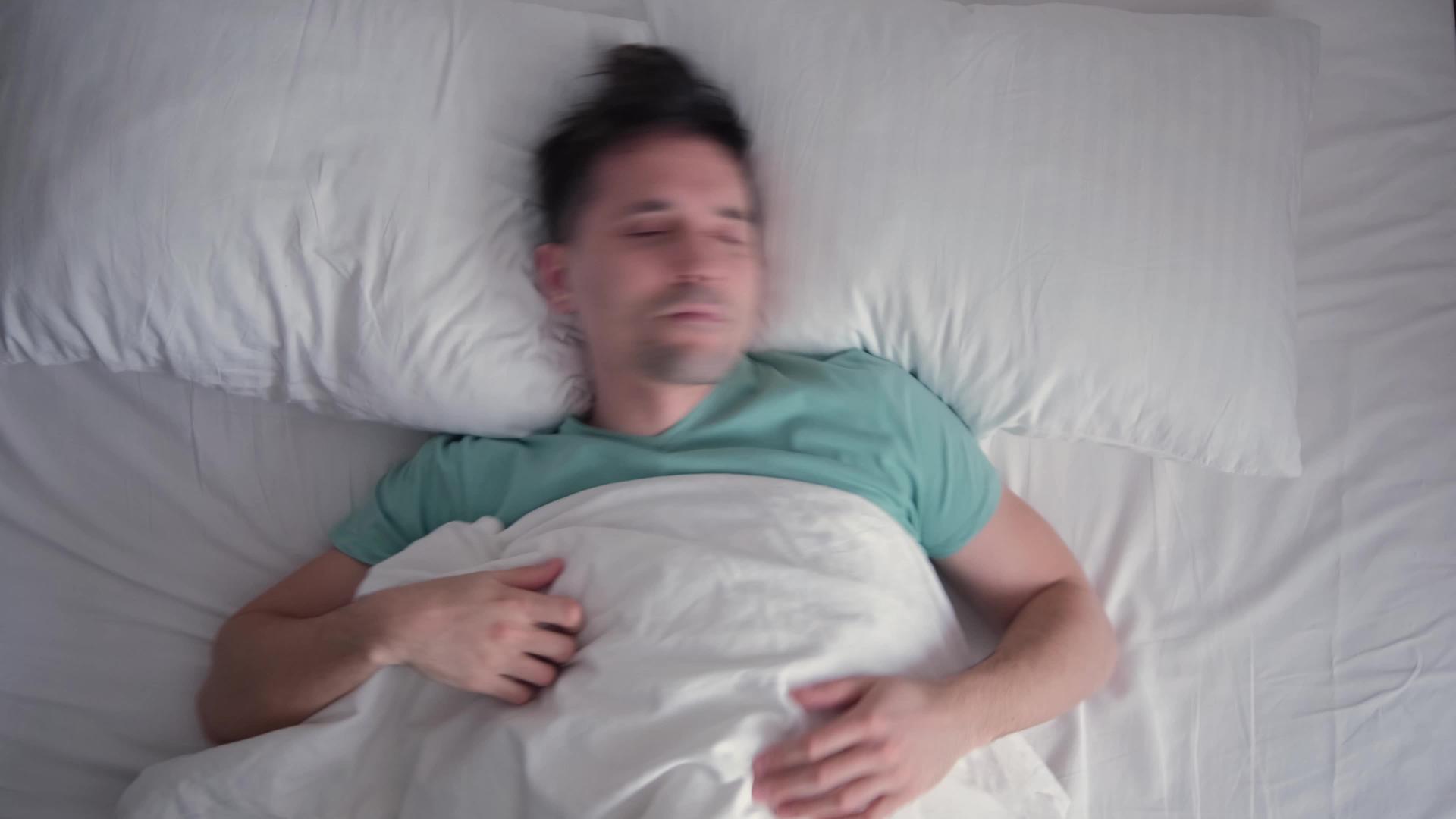 年轻人睡不好 做噩梦 担心白色床上用品 绿松石蓝视频的预览图