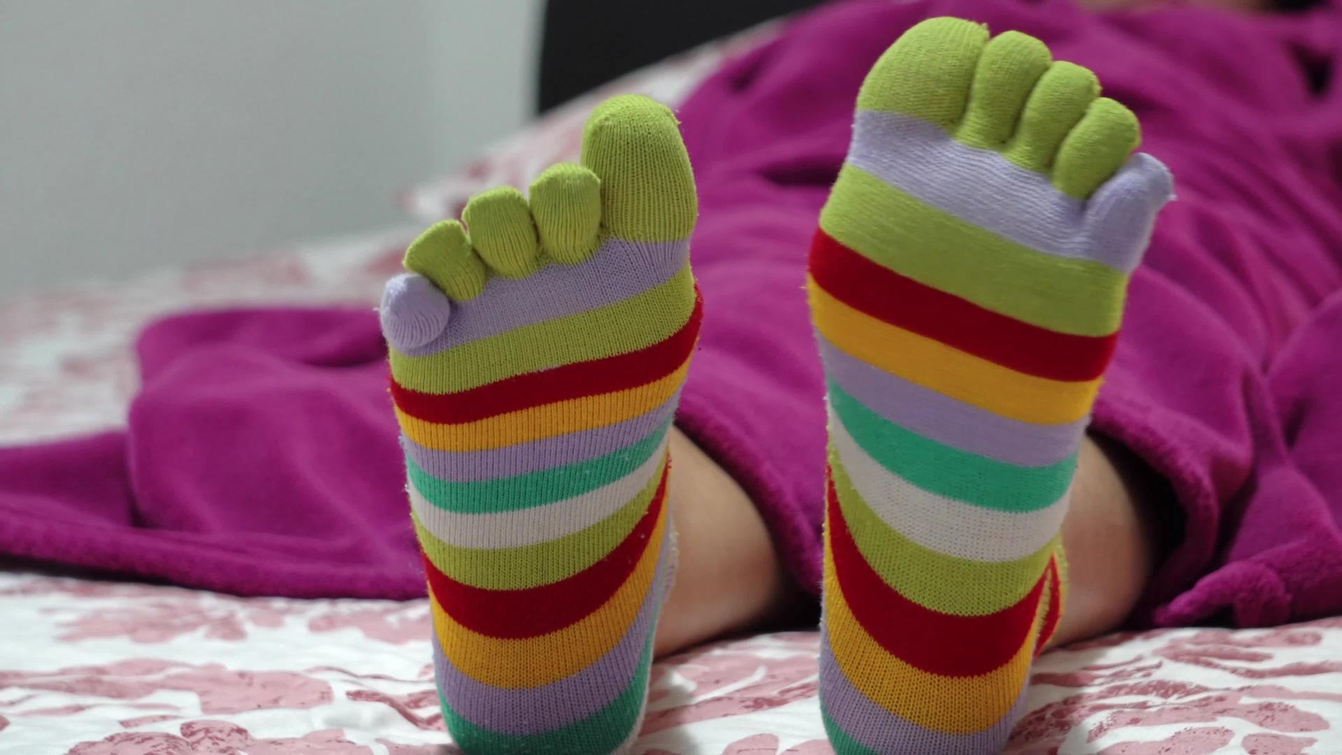 穿着袜子和脚趾的女性腿在床上放松视频的预览图