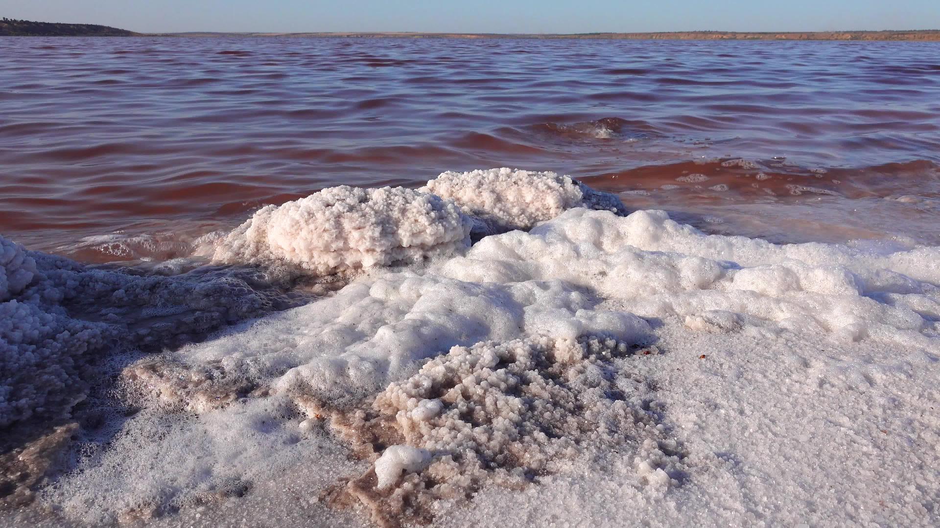 湖岸上的白色泡沫和石头视频的预览图