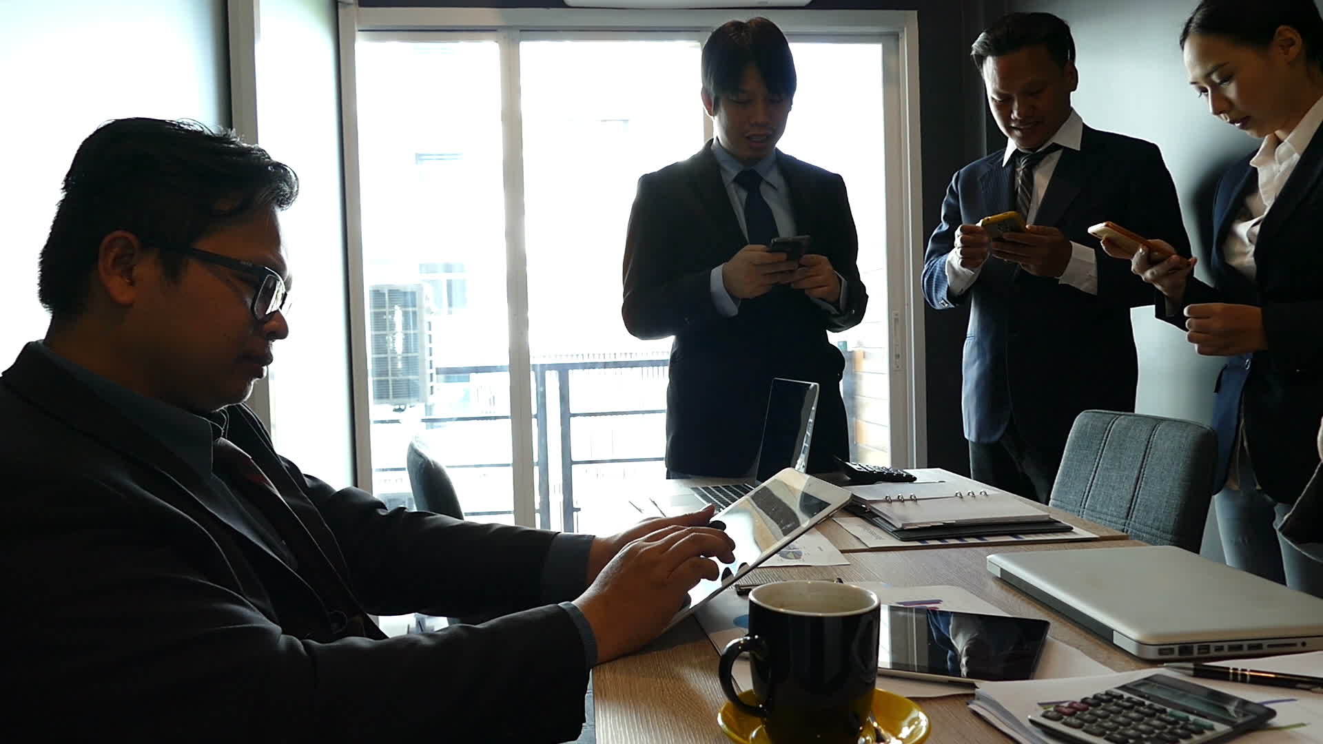 一群商人和女商人在办公室里使用智能手机和应用程序视频的预览图
