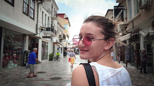 暑假期间年轻的旅游女孩走在奥赫里德的街道上视频的预览图