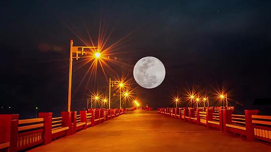 桥上的灯光和满月在黑暗的天空中视频的预览图