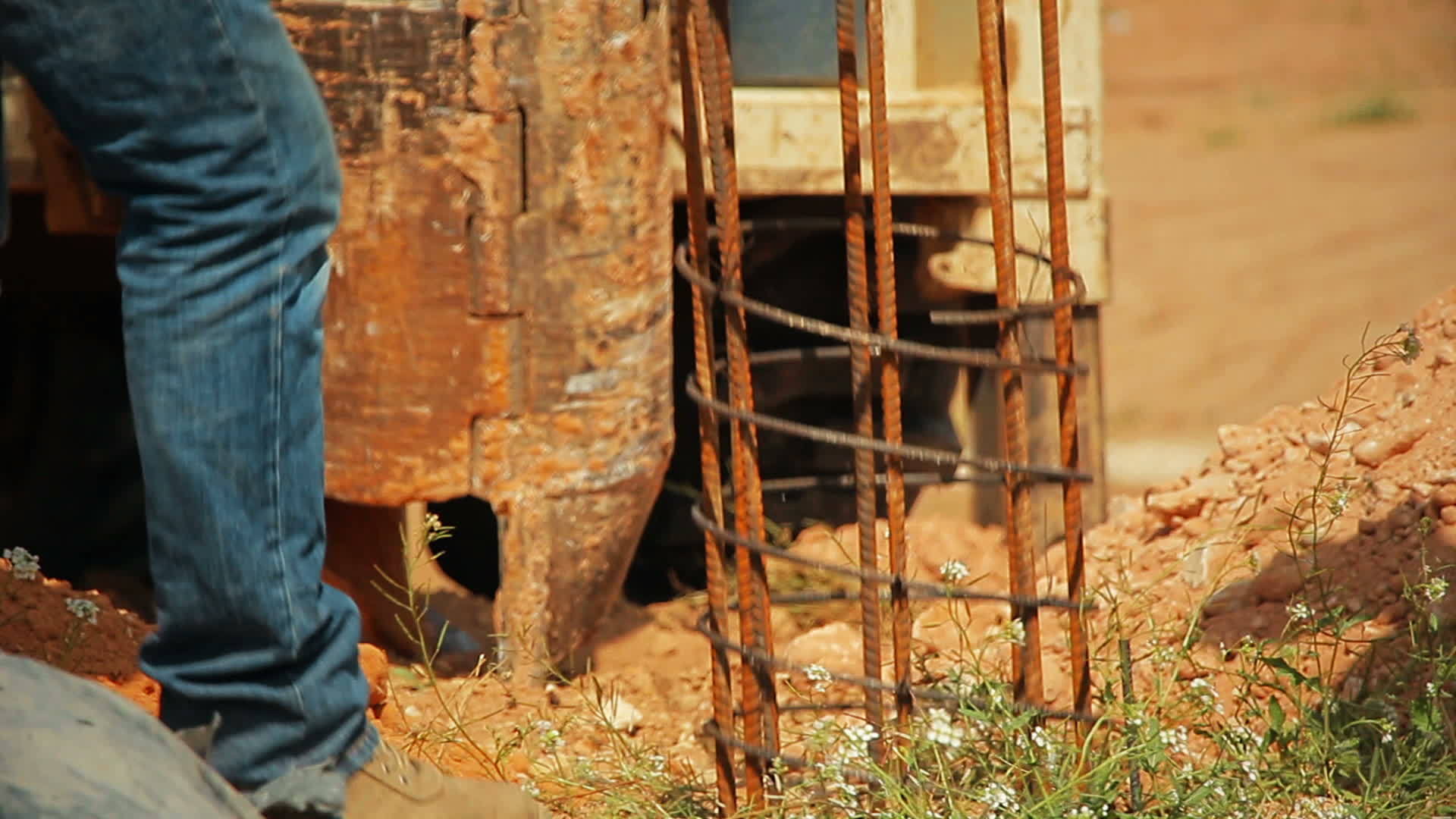 拖拉机抬起一根钢棒放在地上一个洞穴里的建筑工人正在帮助帮助视频的预览图