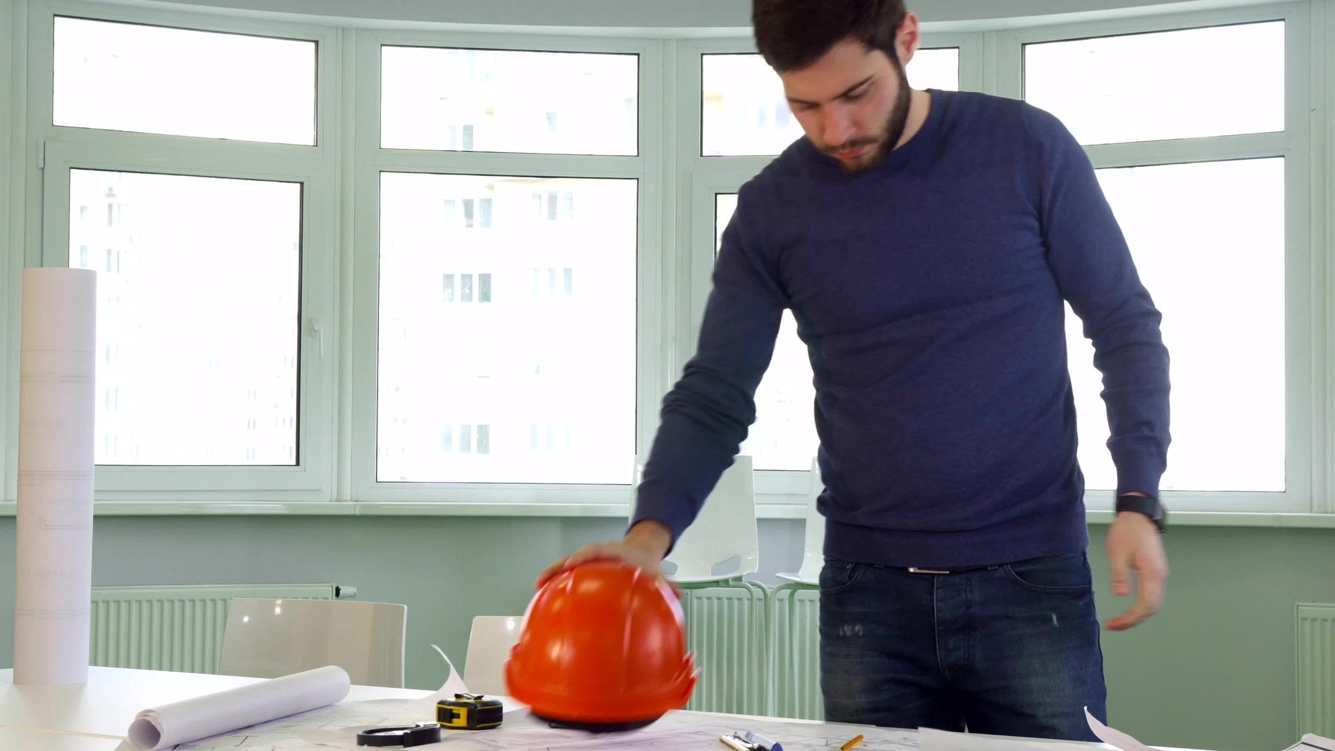 建筑师把硬帽子放在桌子上视频的预览图