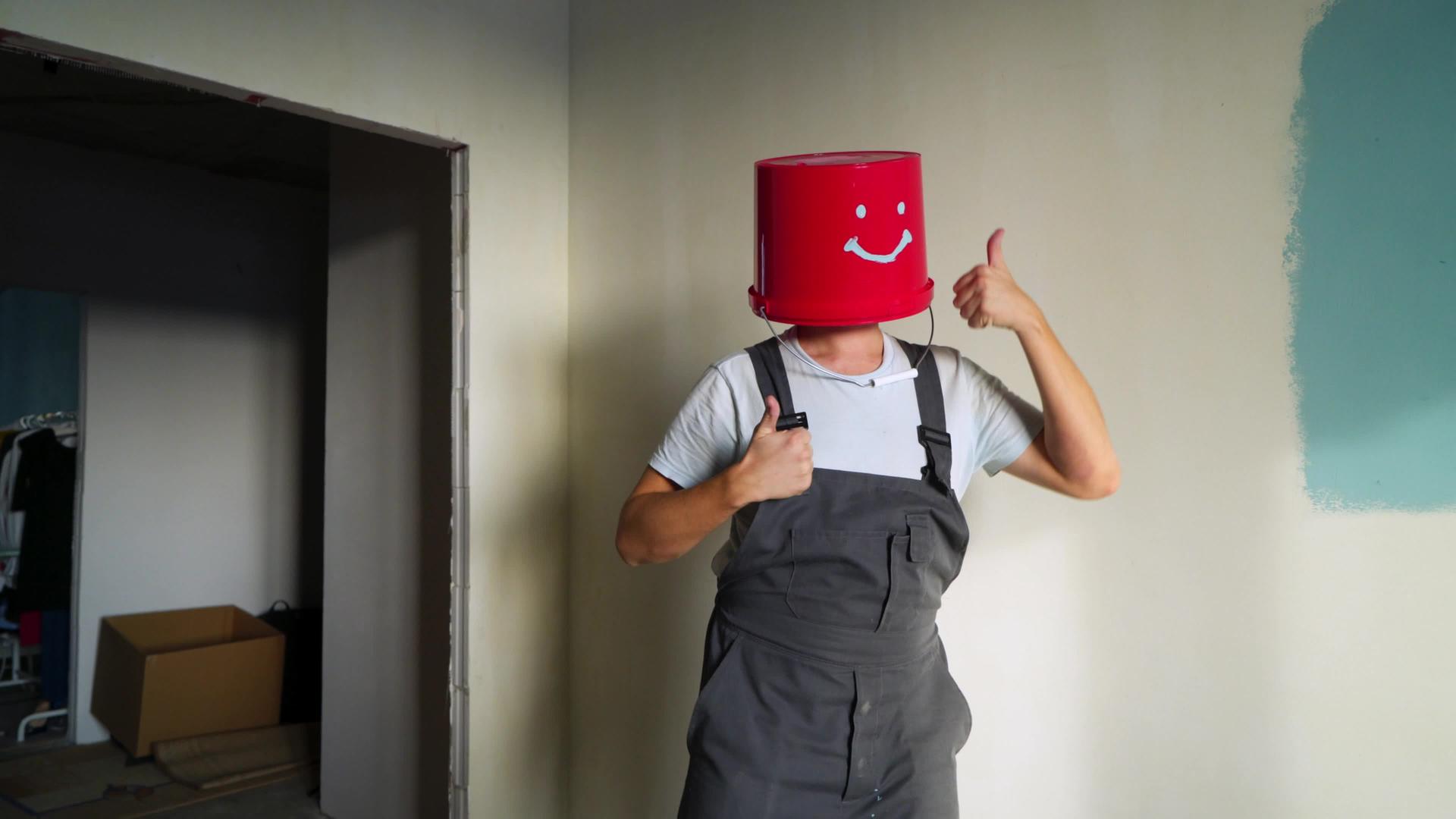 穿着制服的工人头上戴着红色的水桶开心地跳舞视频的预览图