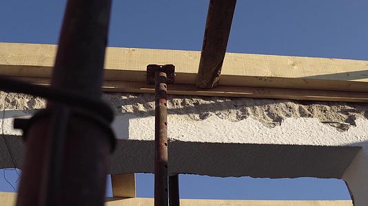 建筑屋顶木匠在屋顶安装工程中用锤子和钉子打破木板视频的预览图