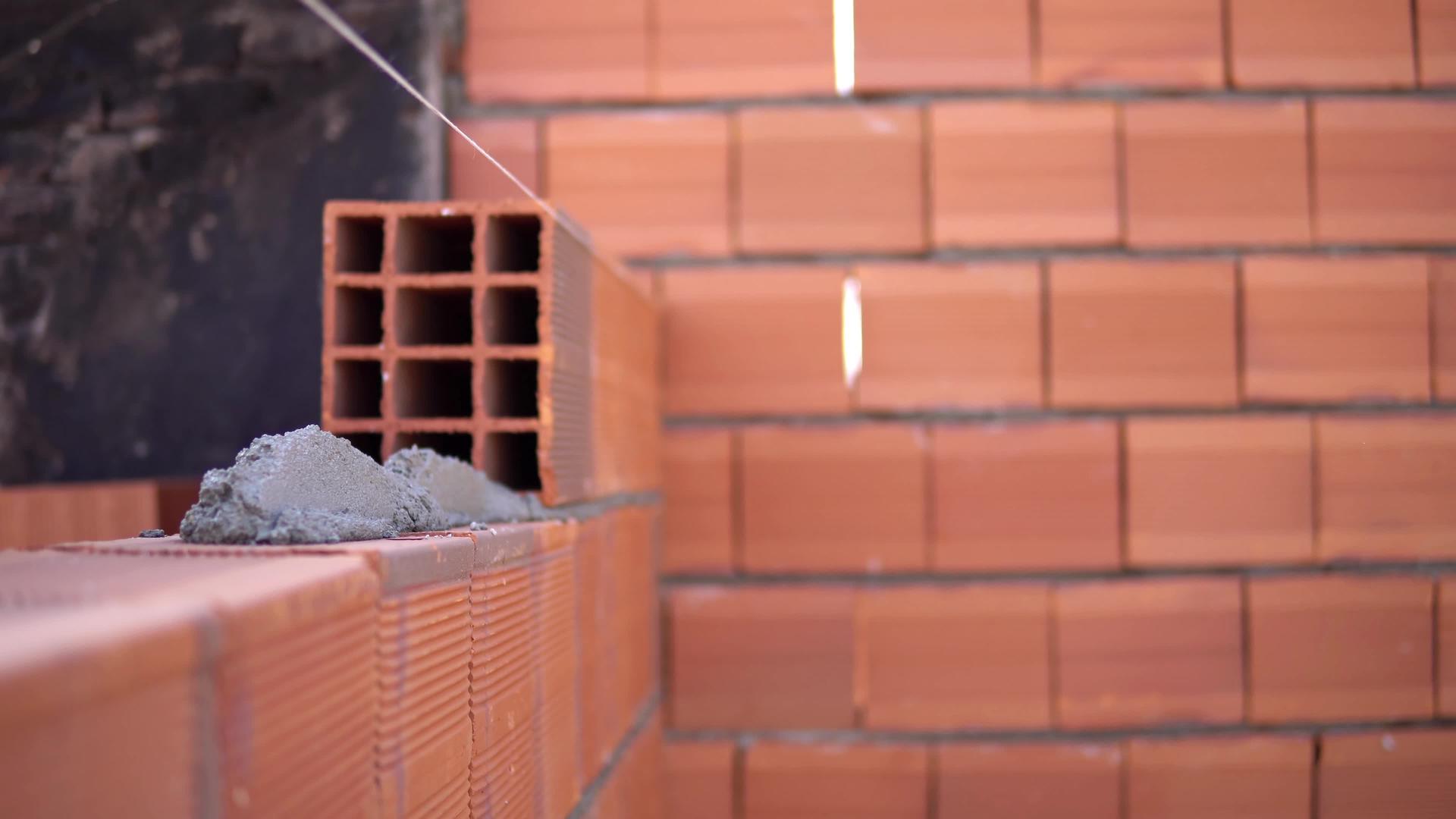 工业细节建筑工人用砖砂浆和油灰刀建造墙壁视频的预览图