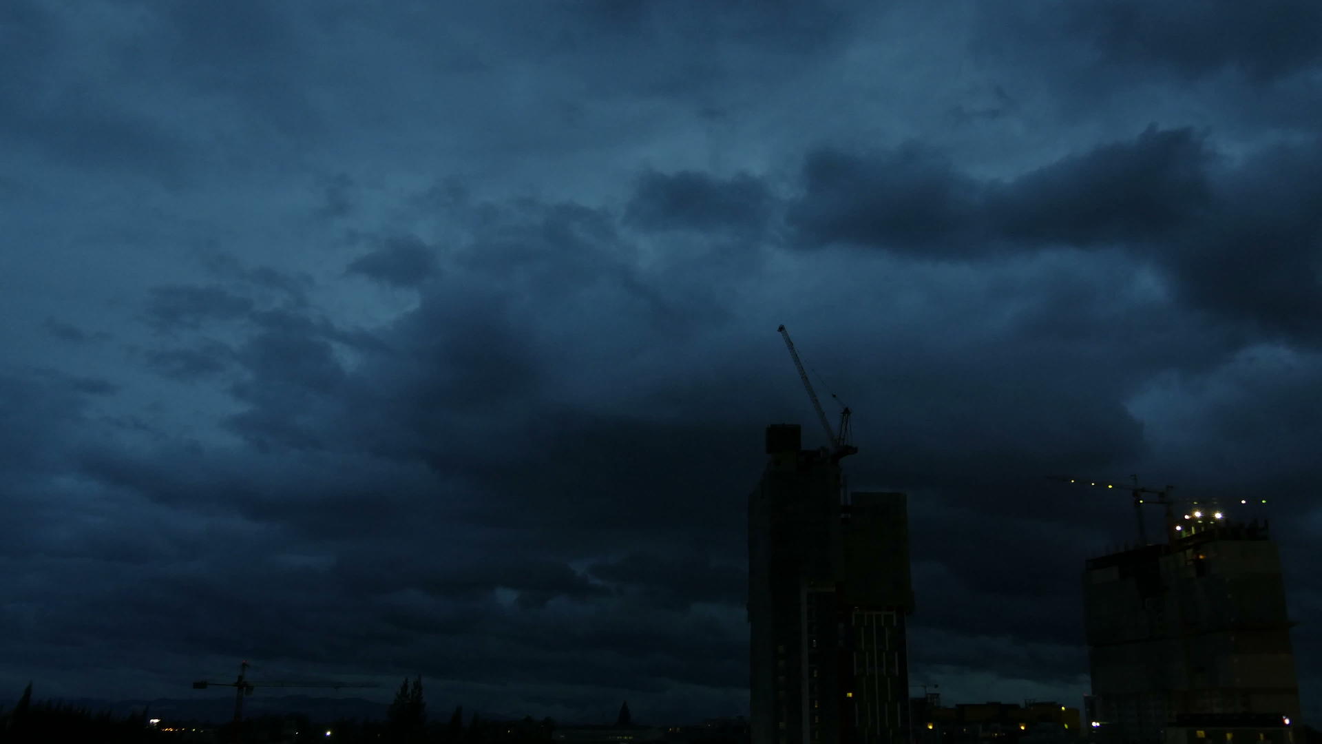 塔式起重机和高层建筑在黄昏时倒塌高层建筑和住宅综合体视频的预览图