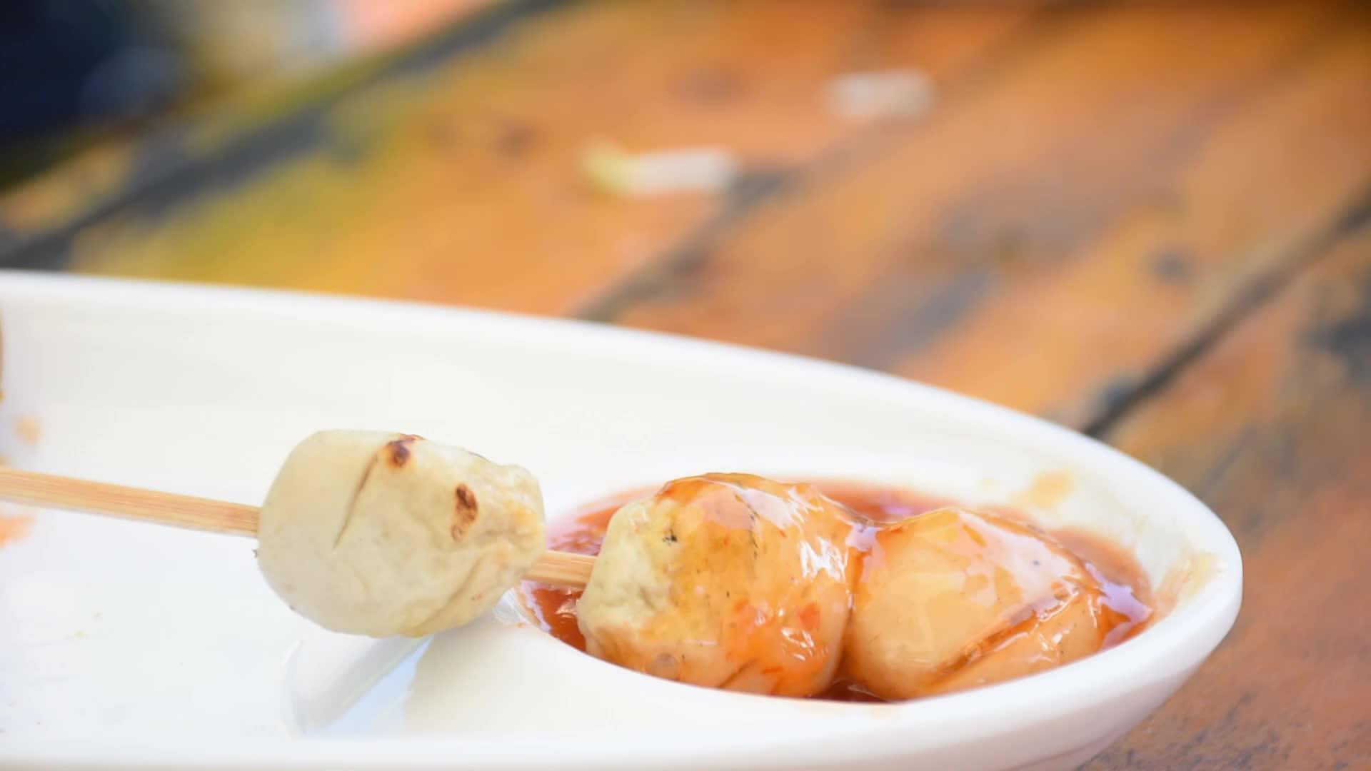 烤猪肉丸和白色塑料盘上的海鲜酱视频的预览图