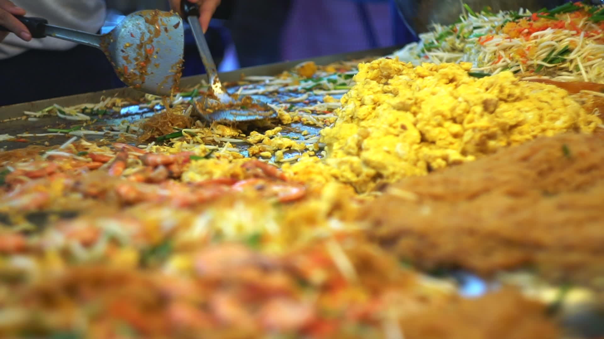 当地街头市场的大锅上手工做饭Thai粉垫粉色面条在视频的预览图