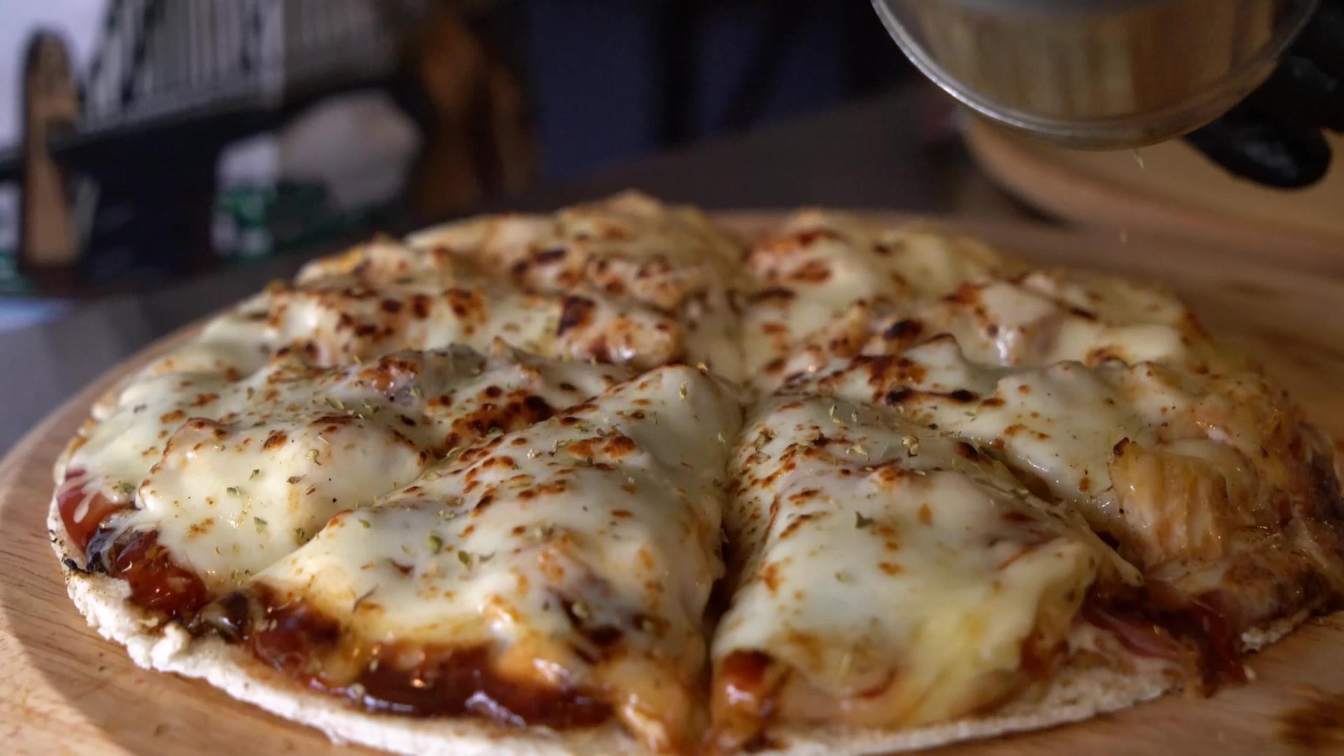 厨师把羊肉酱撒在芝士披萨上视频的预览图