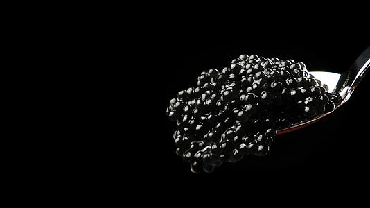黑色背景金属勺中美味的黑鲟鱼鱼子酱特写视频的预览图
