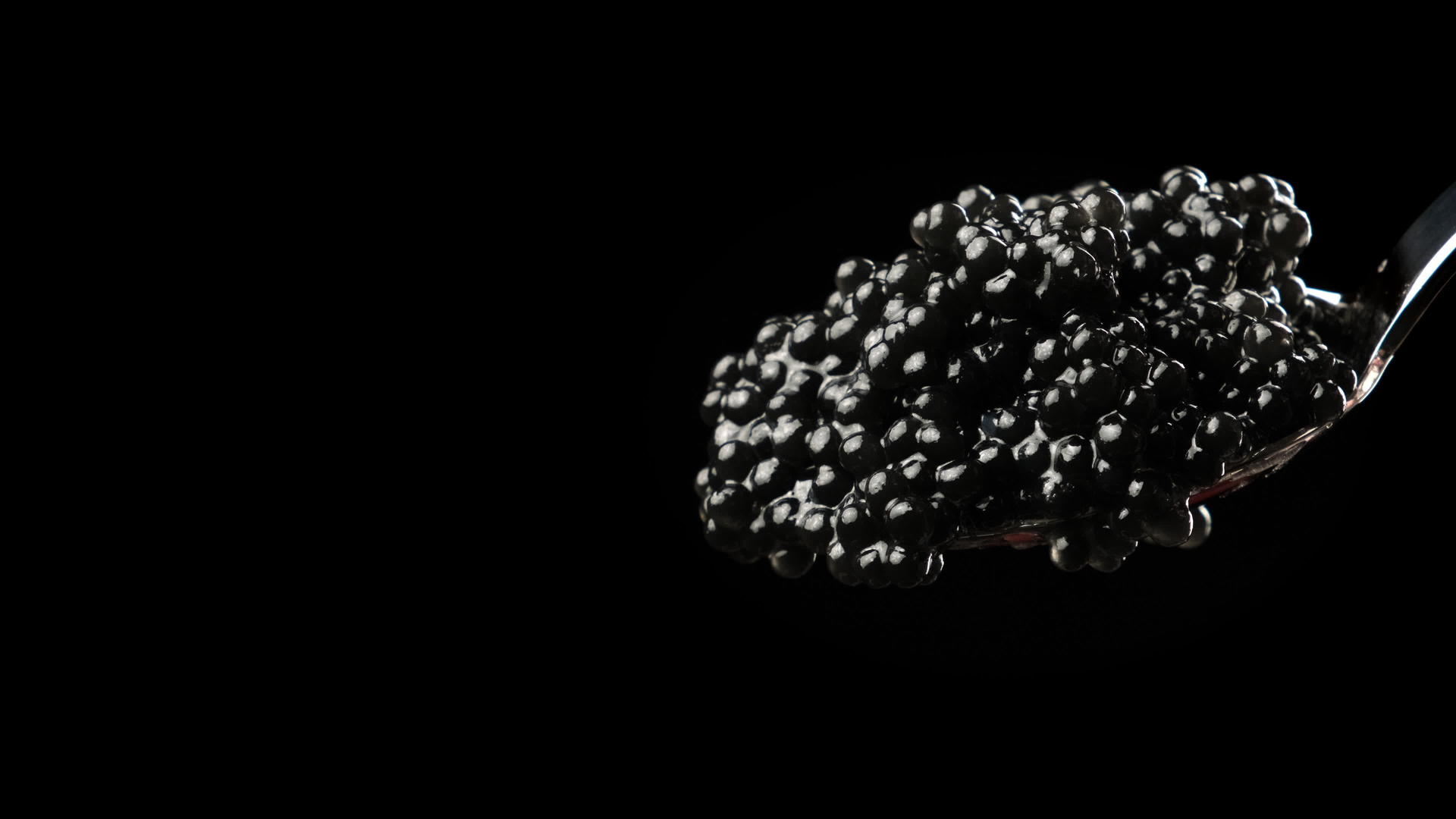 黑底金属勺中的黑鱼子酱视频的预览图
