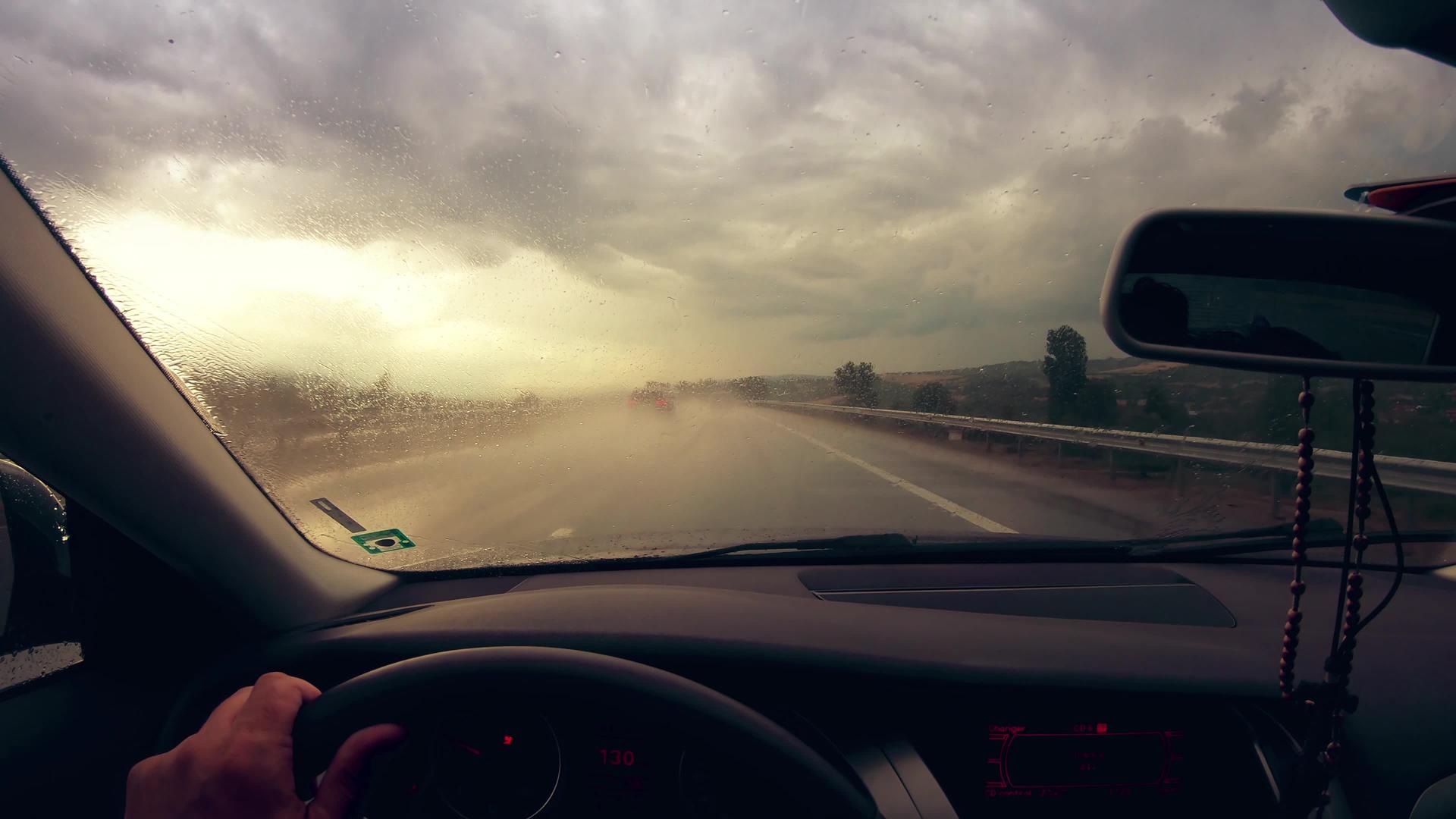 风挡风玻璃上的雨水造成了危险的驾驶条件电影日落等危险视频的预览图