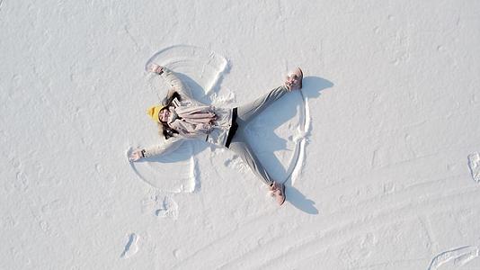 4k航拍女孩雪地冬天撒欢玩闹视频的预览图