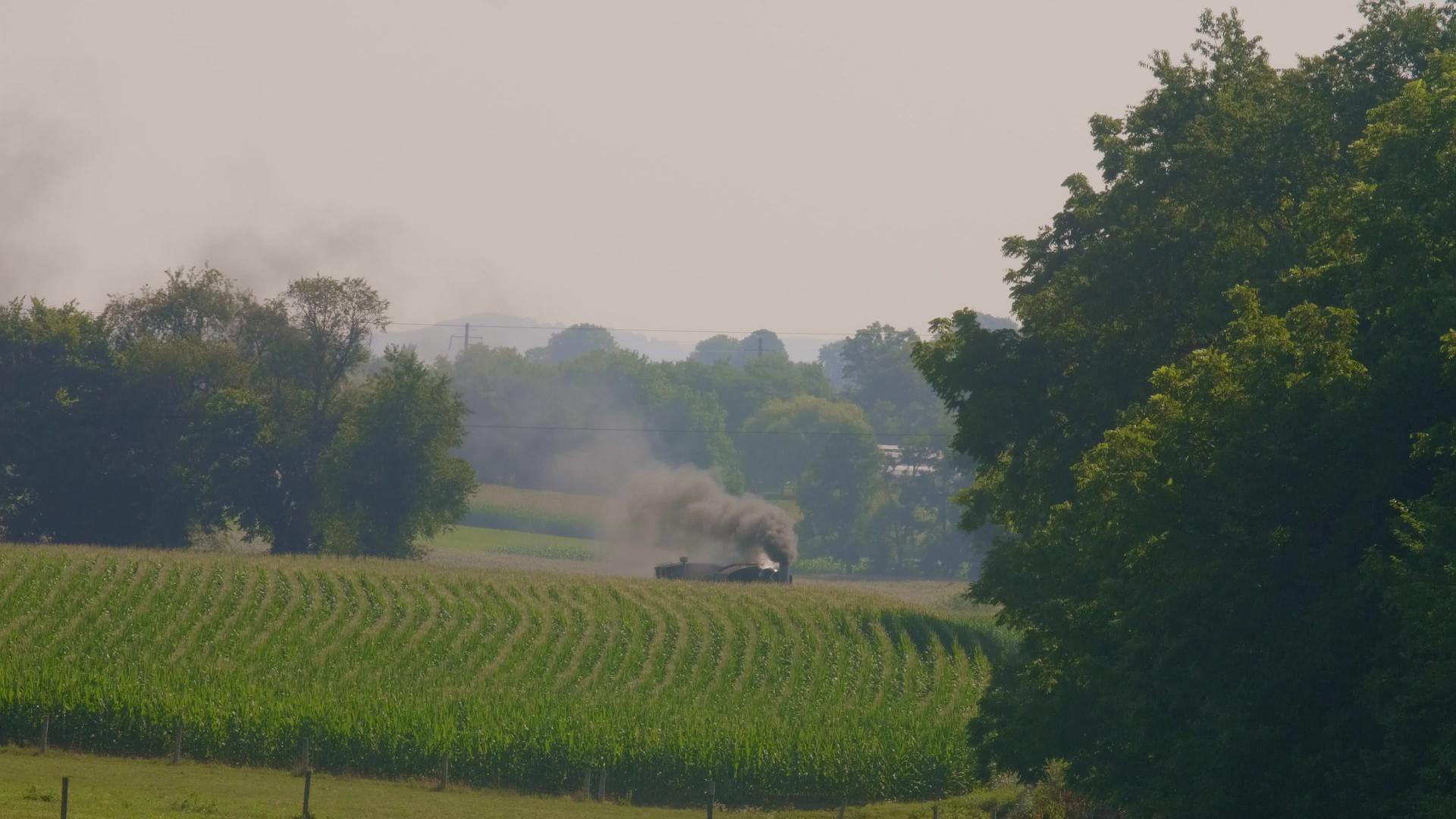 蒸汽发动机接近油玉米田天空中有许多烟雾视频的预览图