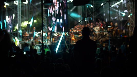 在音乐会期间男人有一个移动相机在人中间显示数字视频的预览图