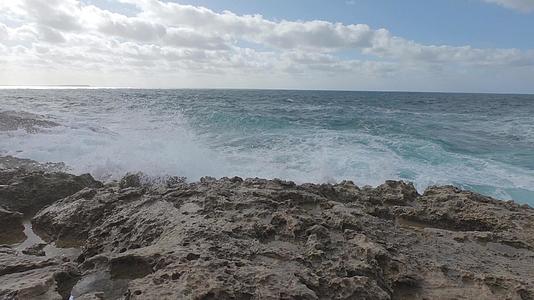 风雨如磐石的大海缓慢移动海浪拍打在石灰岩上视频的预览图