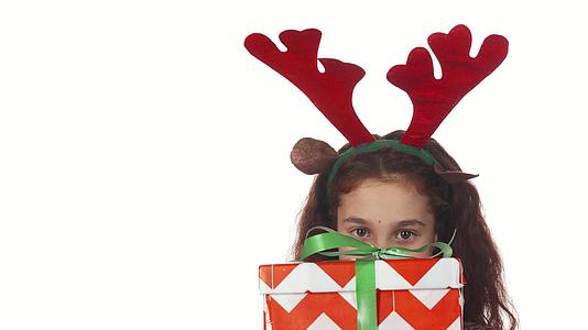 一个可爱的女孩躲在圣诞礼物盒后面视频的预览图