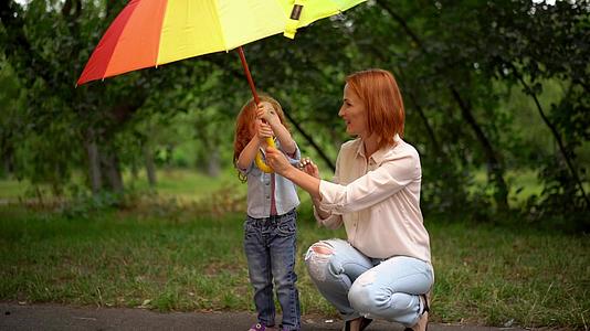母亲和女儿站在彩虹伞下视频的预览图
