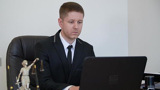 律师用笔记本电脑在他的工作台上工作视频的预览图