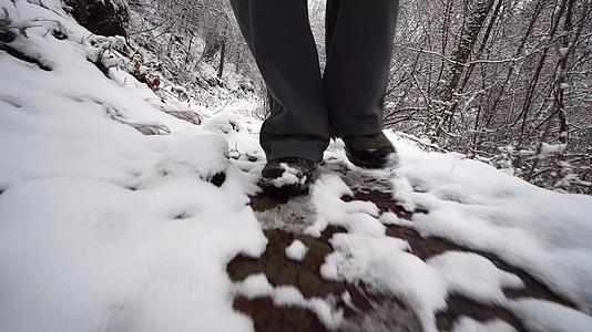 人类徒步旅行被雪覆盖在一条狭窄的危险小路上视频的预览图