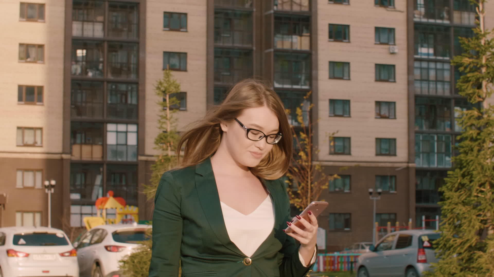 在城市街道上使用移动手机的建筑背景微笑的女性商人视频的预览图