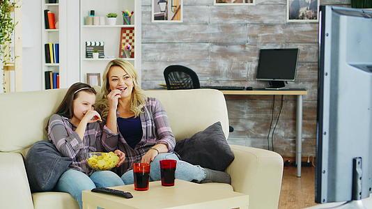 戴着牙套的小女孩和妈妈坐在沙发上视频的预览图