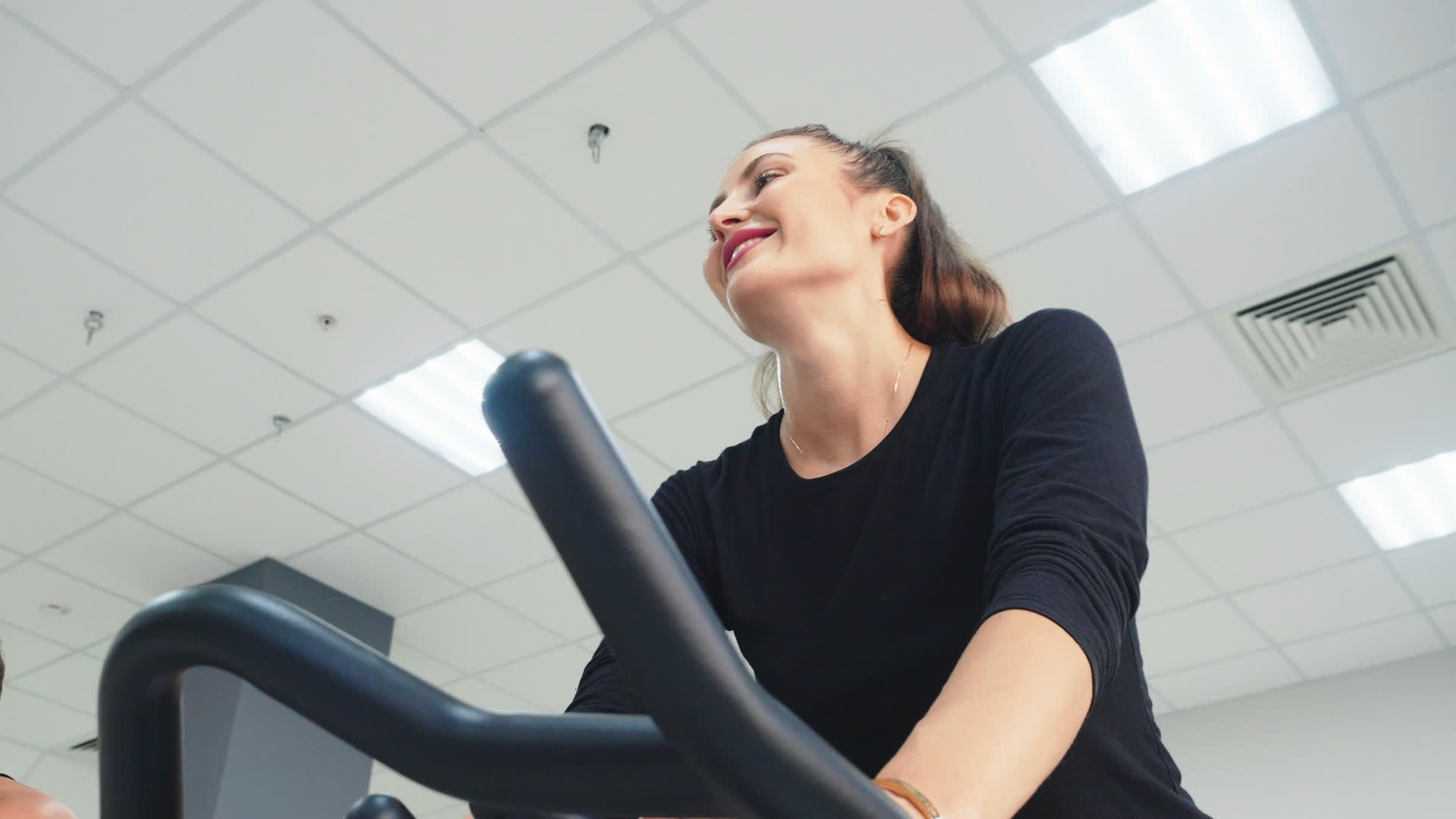 微笑的女性在健身房的自行车课上训练室内自行车视频的预览图