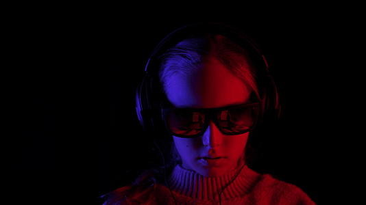 微笑的女孩戴着耳机和黑色太阳镜带着红色和蓝色的背光视频的预览图