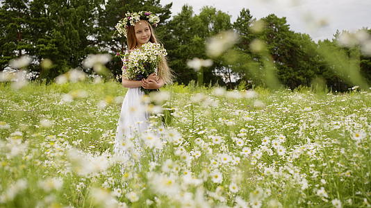 微笑的年轻女孩站在花圈和花束的开花区视频的预览图