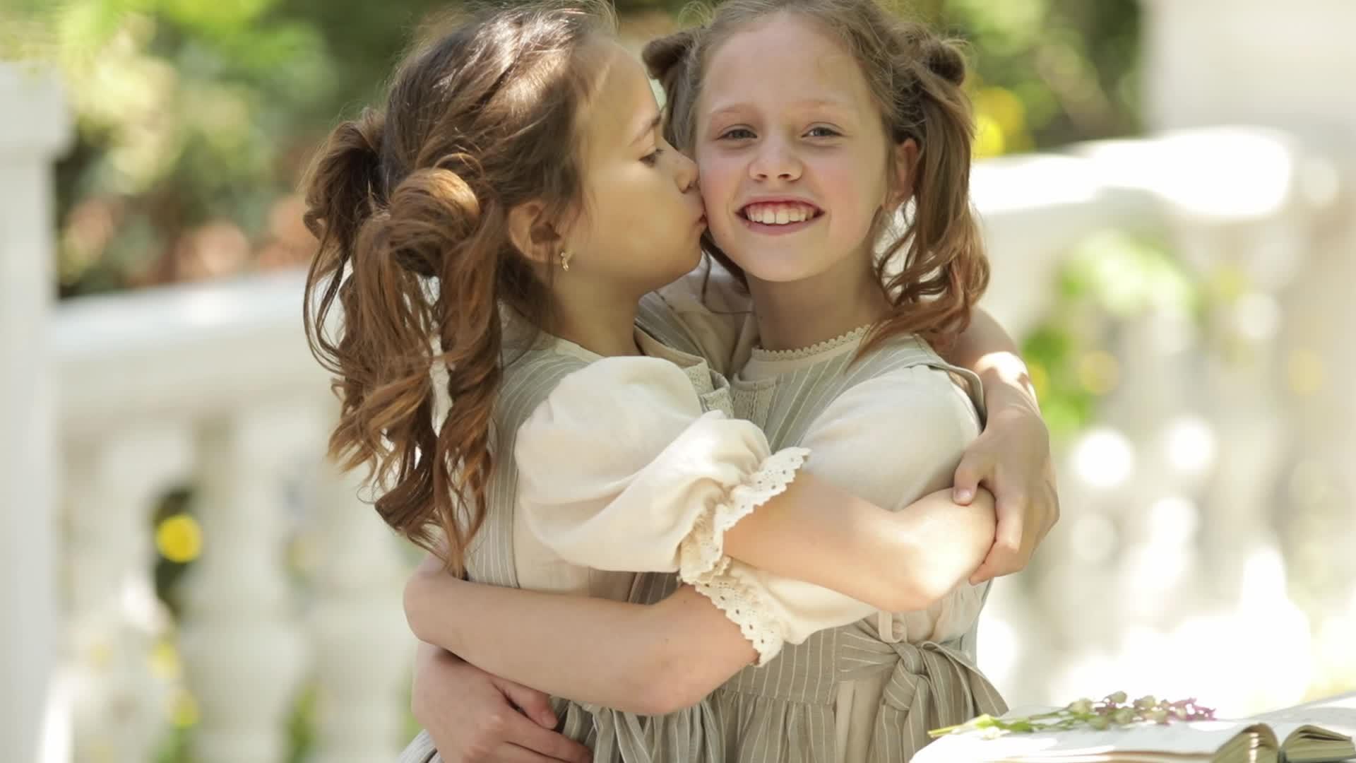 两个姐妹朋友拥抱亲吻对方的脸颊视频的预览图