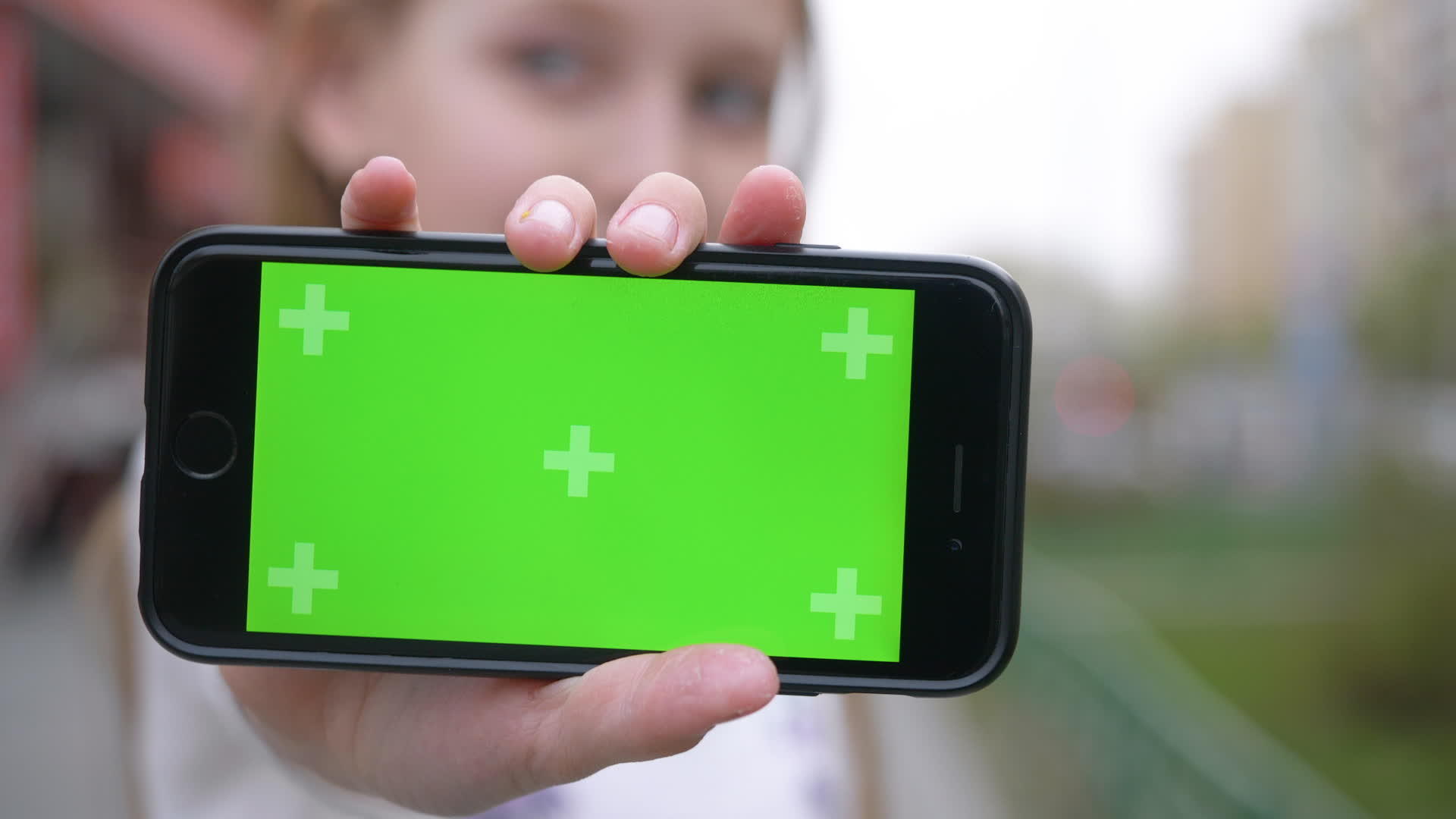 漂亮的女孩展示智能手机绿屏游戏视频的预览图