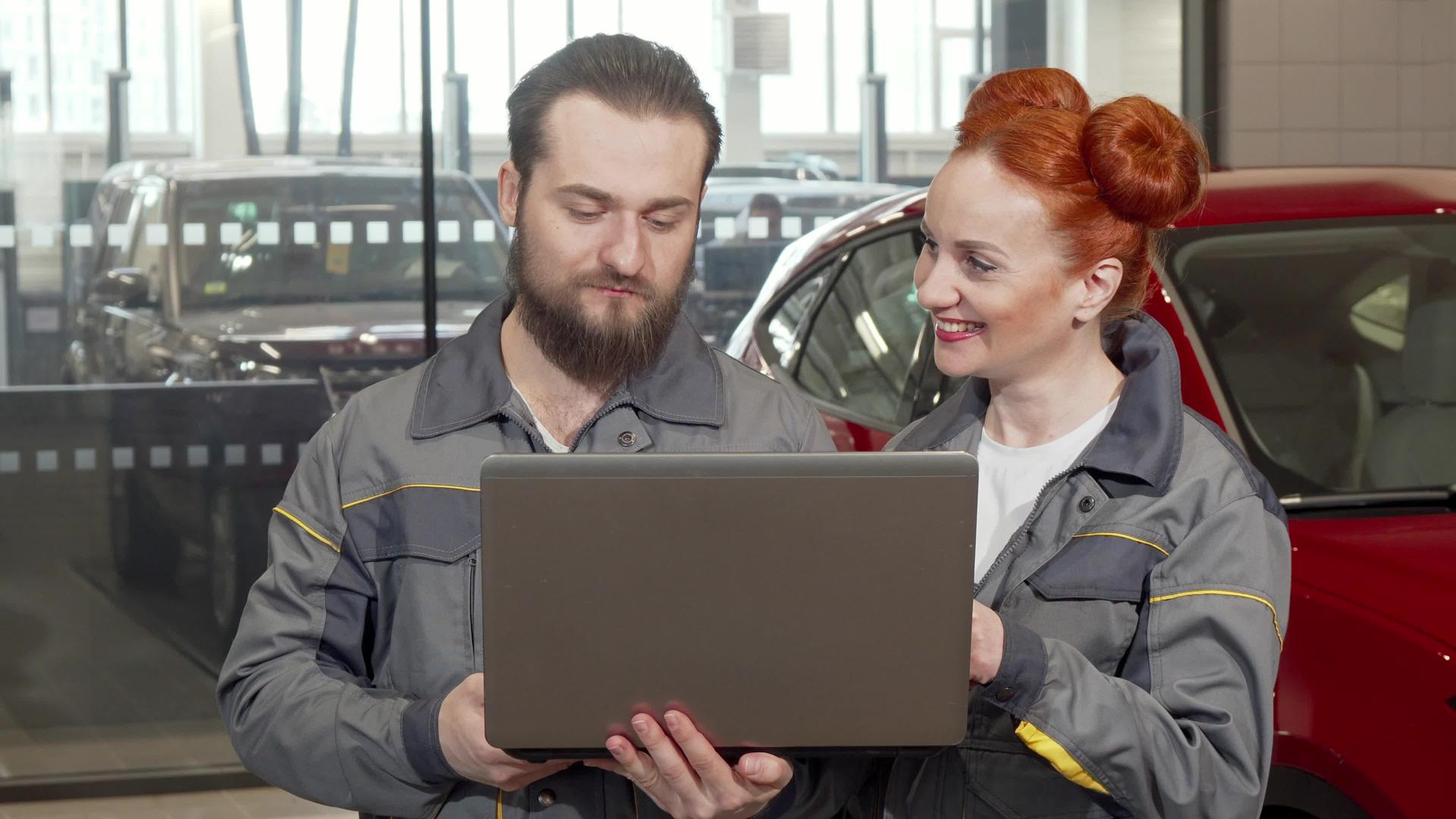 和女同事一起在停车场工作用膝盖电脑修理汽车视频的预览图