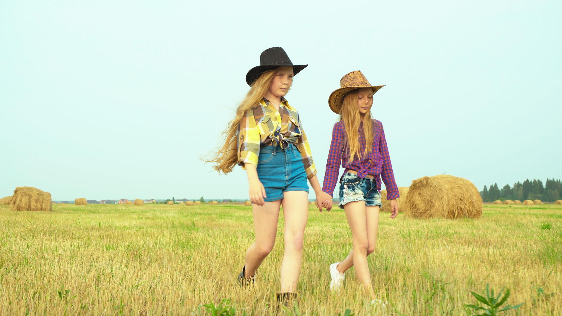 两个女牛仔走在农村的田野里视频的预览图