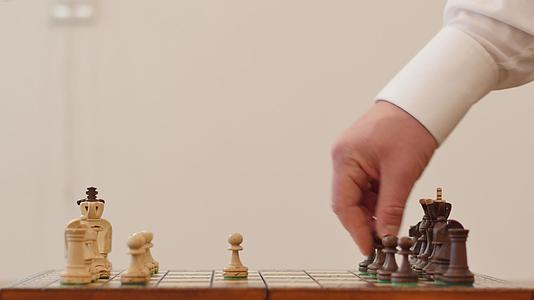 两名英俊的职业棋手穿着白衬衫在船上玩国际象棋视频的预览图